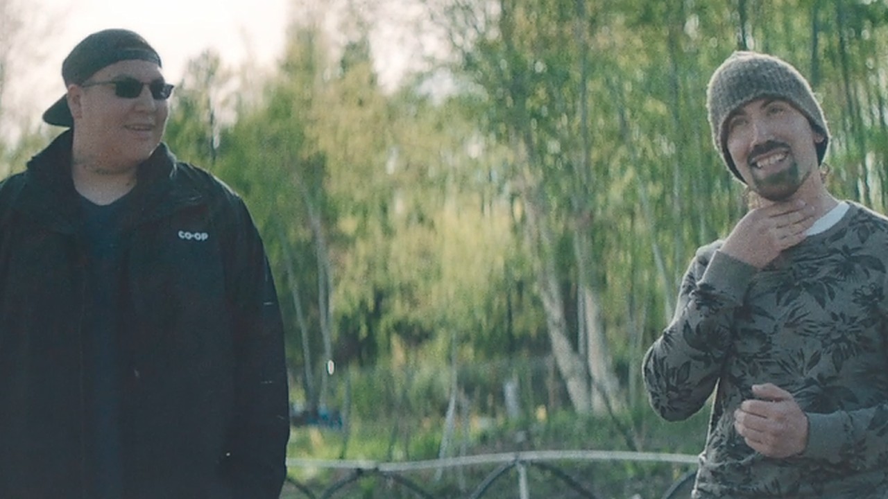 Indigenous men standing in a garden smiling at the camera