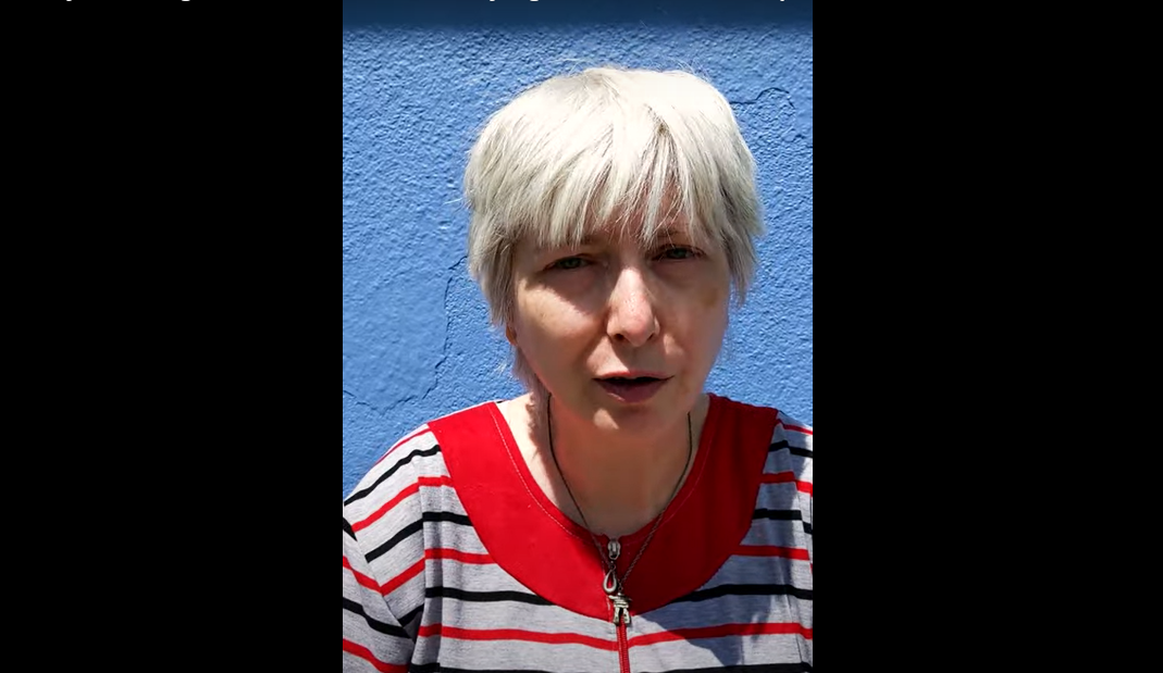 Headshot of an older white woman with short grey hair wearing a striped shirt